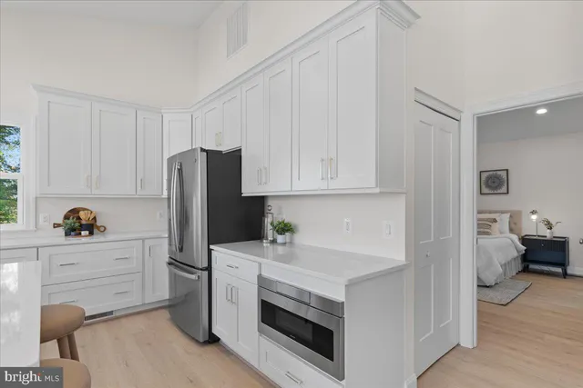 a kitchen with stainless steel appliances white cabinets and a window
