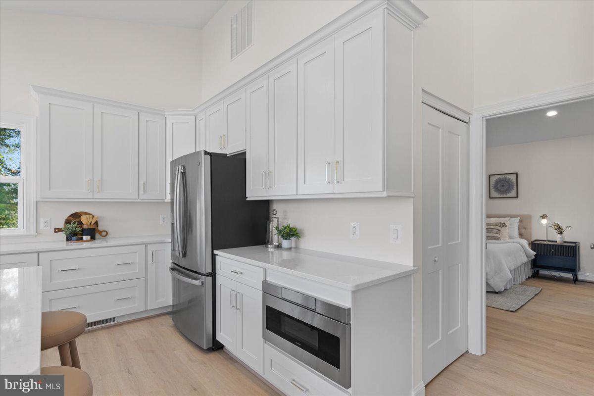 2825 Ridge Road Huntingtown, MD 20639 - Photo 17 of 67 a kitchen with a refrigerator stove and white cabinets