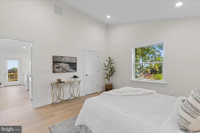 a large kitchen with kitchen island a large counter space a large window appliances and cabinets