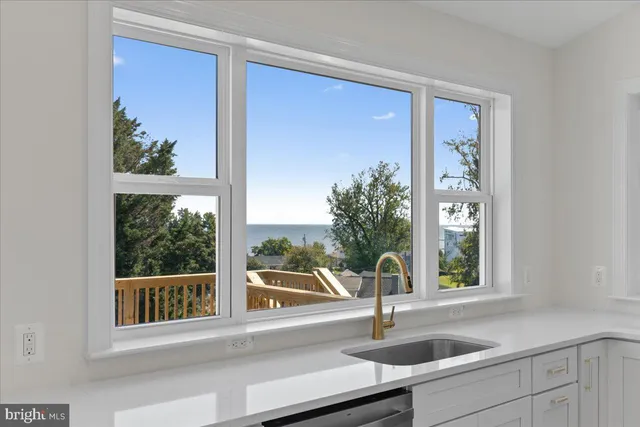 a front view of house with yard and trees in the background