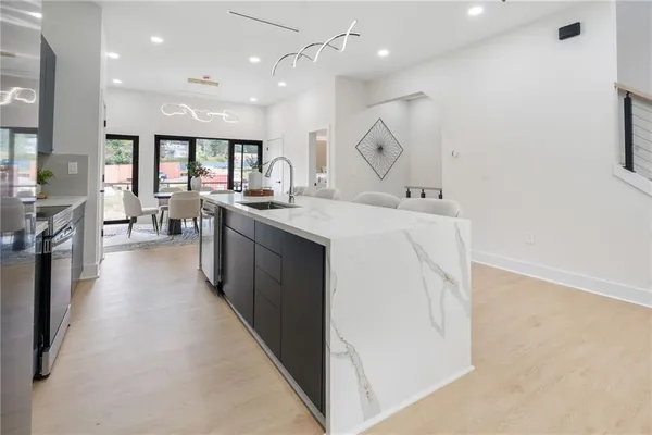 a large white kitchen with lots of counter top space stainless steel appliances and a window