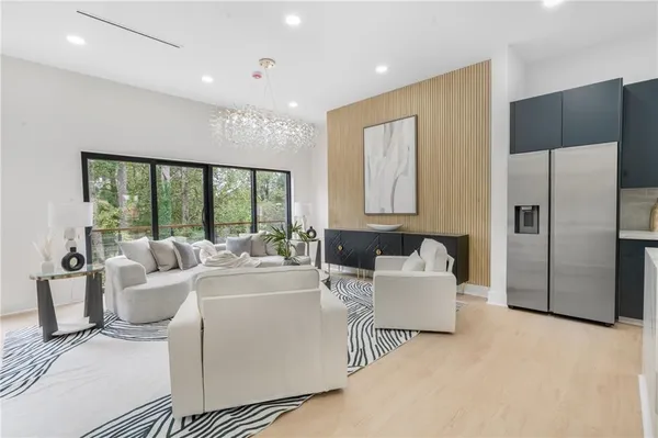 a living room with furniture a chandelier and a flat screen tv
