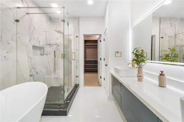 a white bath tub sitting in a bathroom and a shower