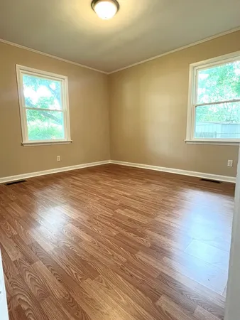 a view of empty room with wooden floor