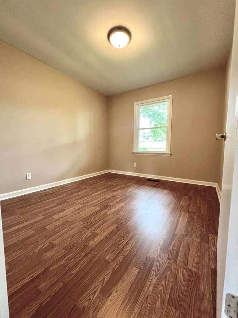 210 Roney Drive Hopkinsville, KY 42240 - Photo 20 of 29 an empty room with wooden floor and windows