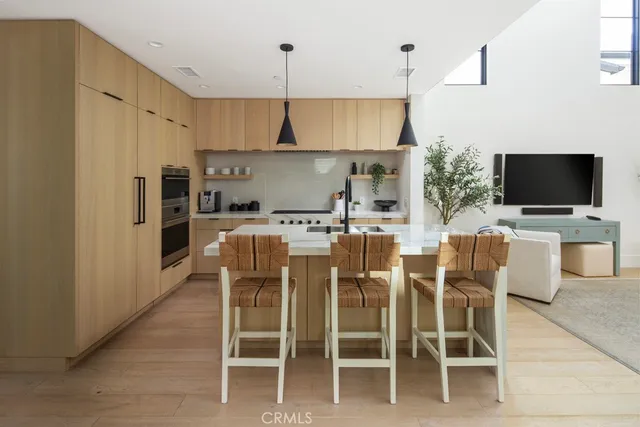 a kitchen with stainless steel appliances kitchen island granite countertop a table and chairs in it