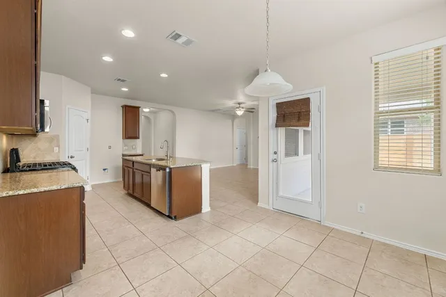 a kitchen with stainless steel appliances granite countertop a stove a sink a refrigerator and a cabinets