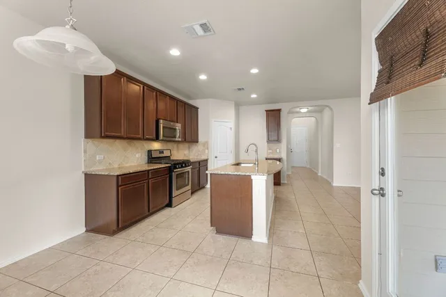 a kitchen with a refrigerator and a stove top oven