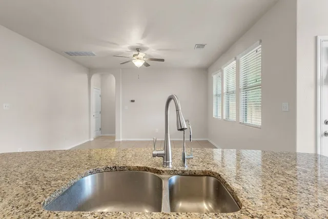 a kitchen with a sink a faucet a clock and cabinets