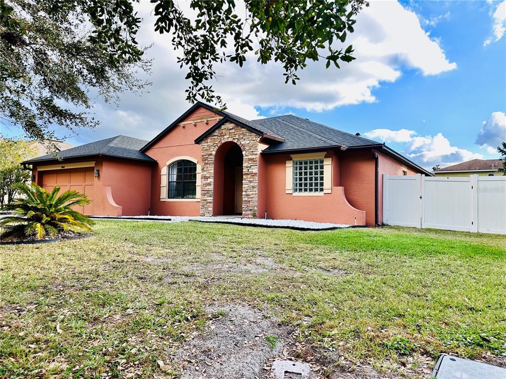 3840 Marietta Way St. Cloud, FL 34772 - Photo 2 of 44 a front view of a house with garden