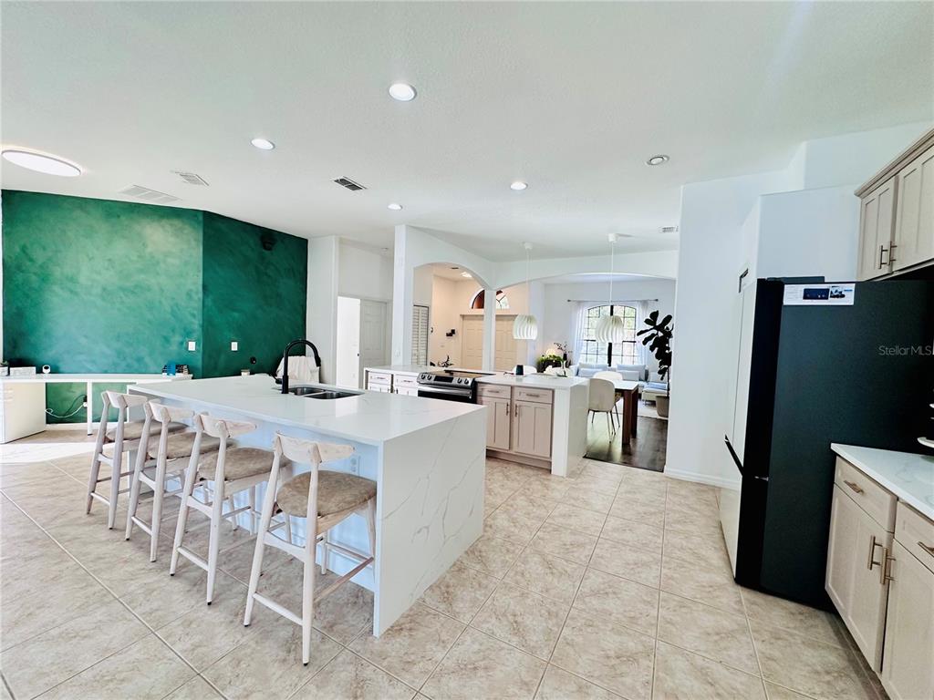 3840 Marietta Way St. Cloud, FL 34772 - Photo 26 of 44 a kitchen with stainless steel appliances a table and chairs