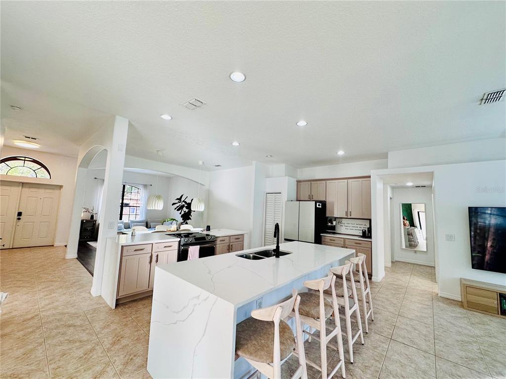 3840 Marietta Way St. Cloud, FL 34772 - Photo 29 of 44 a kitchen with stainless steel appliances kitchen island granite countertop a refrigerator and a sink