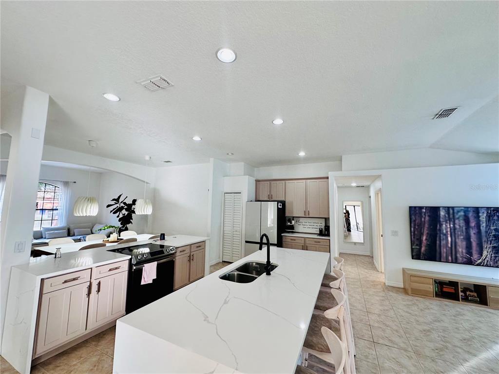 3840 Marietta Way St. Cloud, FL 34772 - Photo 30 of 44 a kitchen with stainless steel appliances kitchen island granite countertop a sink and cabinets