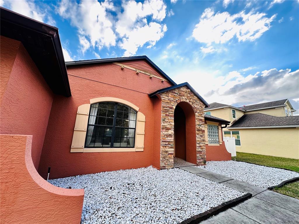 3840 Marietta Way St. Cloud, FL 34772 - Photo 3 of 44 a front view of a house with garden