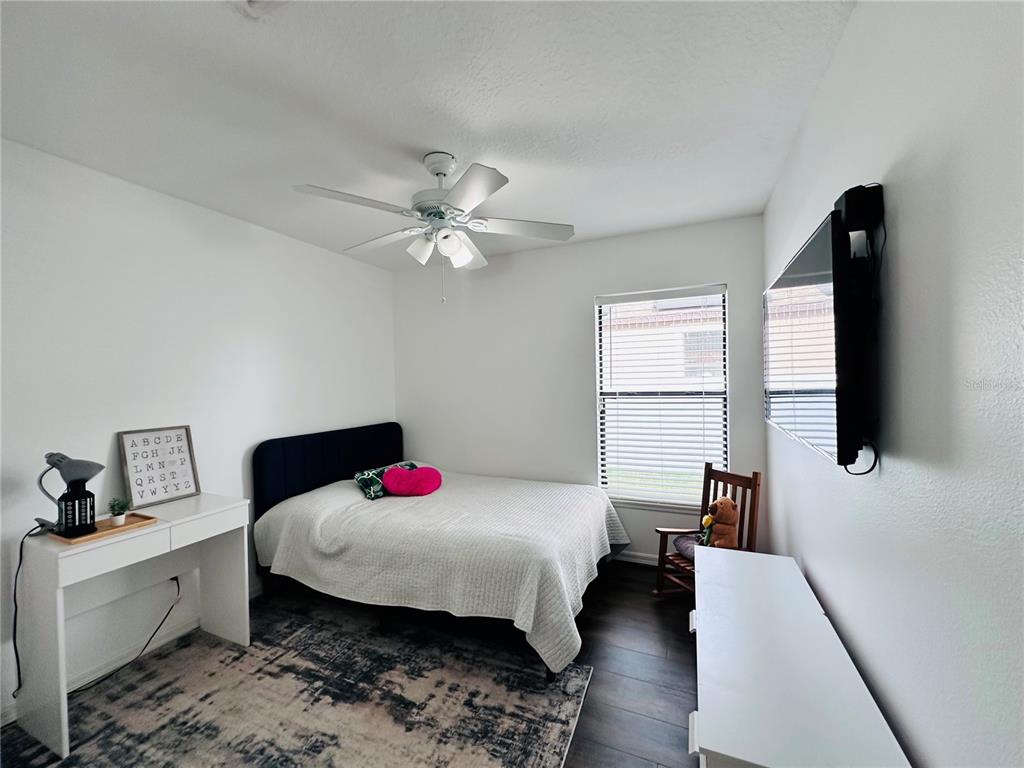 3840 Marietta Way St. Cloud, FL 34772 - Photo 31 of 44 a bedroom with a bed a flat screen tv and dresser