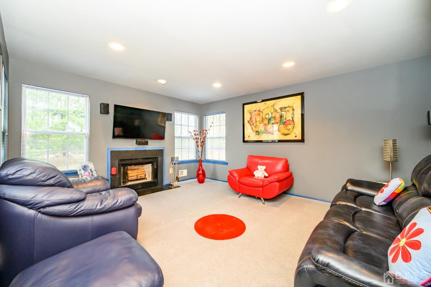 1 Rutgers Drive Howell, NJ 07731 - Photo 16 of 43 a living room with furniture a flat screen tv and a fireplace