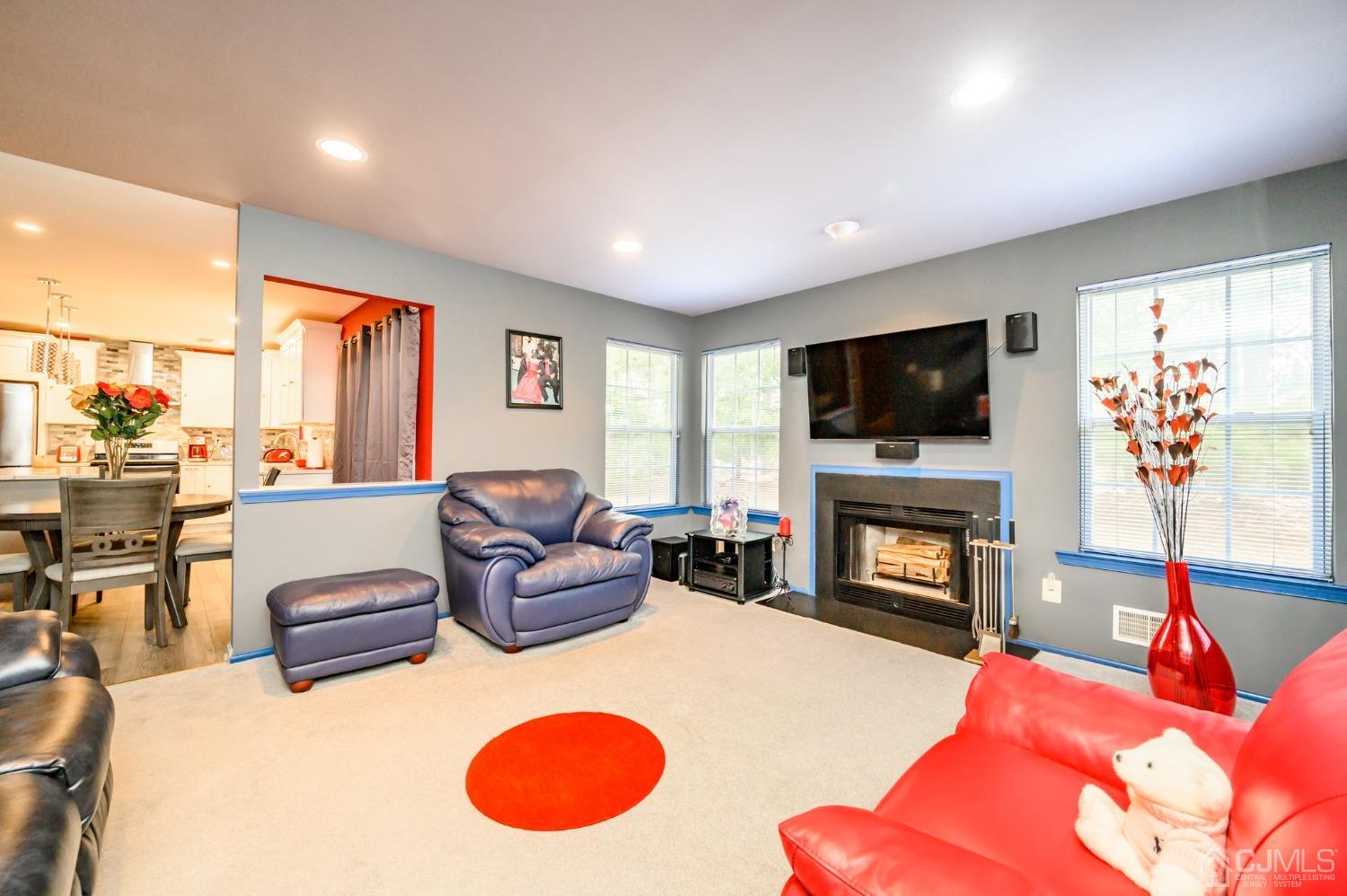 1 Rutgers Drive Howell, NJ 07731 - Photo 17 of 43 a living room with furniture a flat screen tv and a fireplace