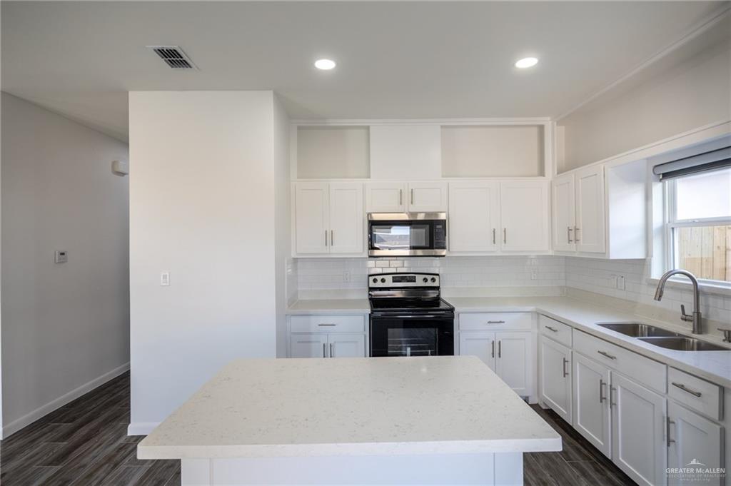 1106 Copper Avenue, Unit 4 San Juan, TX 78589 - Photo 11 of 20 a kitchen with stainless steel appliances a stove refrigerator sink and white cabinets