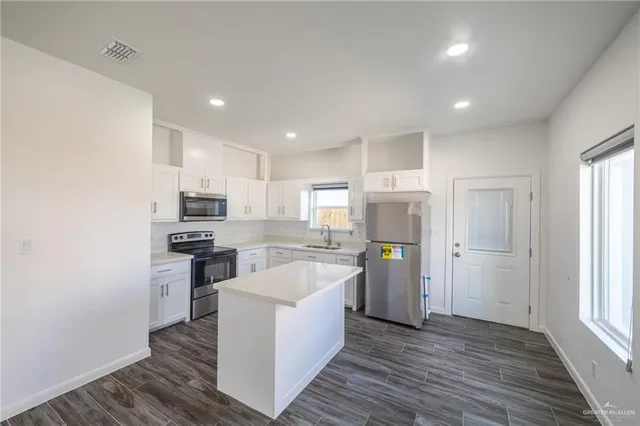 a kitchen with refrigerator and cabinets