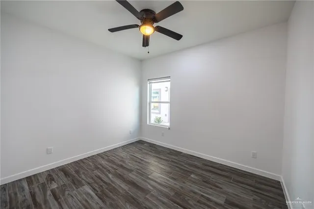 an empty room with a window and a ceiling fan
