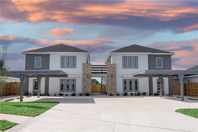 front view of a brick house with a yard