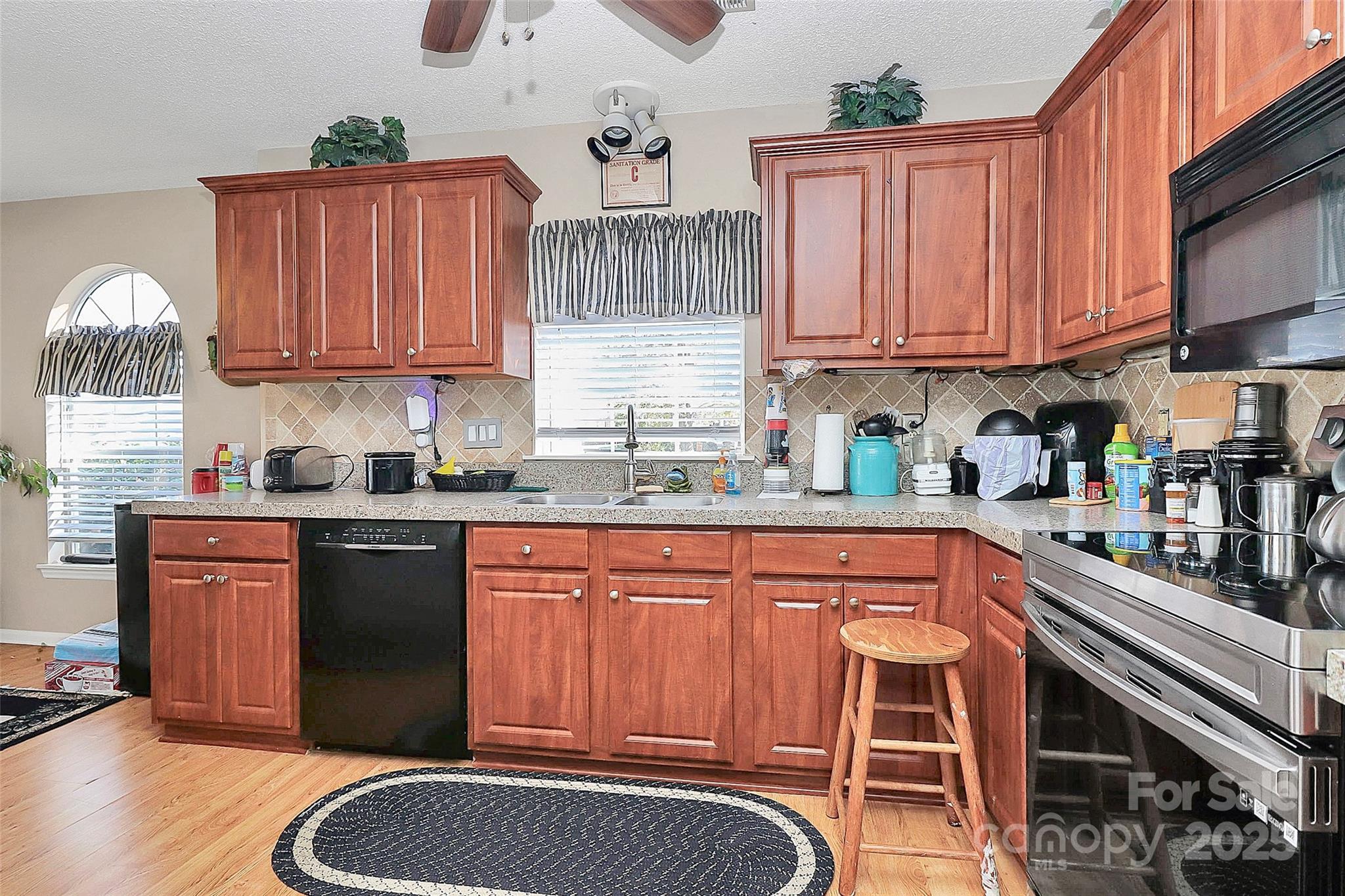 493 Debra Circle Southwest Concord, NC 28025 - Photo 7 of 27 a kitchen with stainless steel appliances granite countertop a sink dishwasher and cabinets with wooden floor