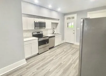 a kitchen with stainless steel appliances granite countertop a stove a sink and a refrigerator