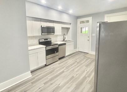 400 Prospect Street, Unit B Jeannette, PA 15644 - Photo 3 of 10 a kitchen with stainless steel appliances granite countertop a stove a sink and a refrigerator