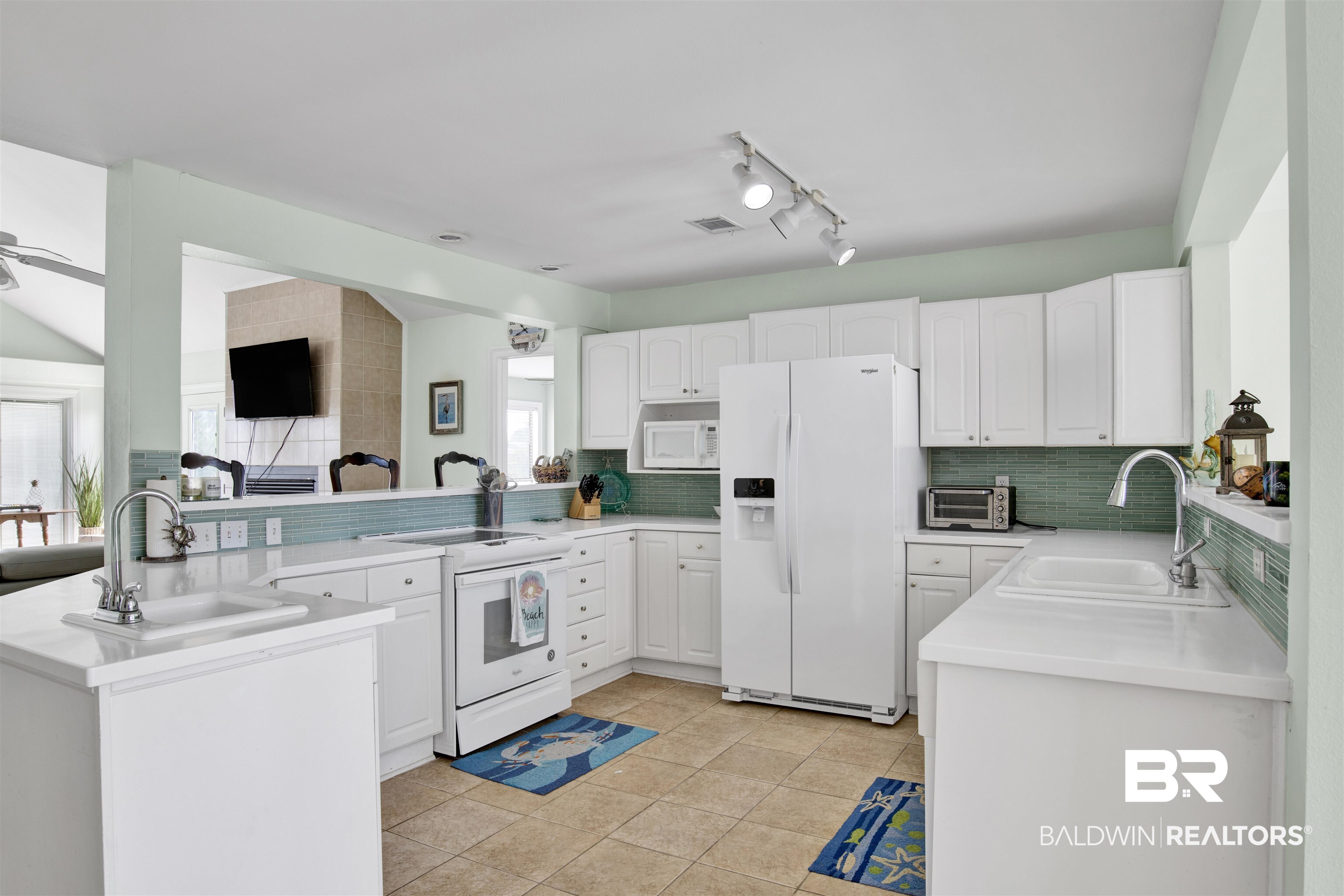 33093 River Road Orange Beach, AL 36561 - Photo 7 of 30 Kitchen featuring light tile patterned flooring, white appliances, sink, kitchen peninsula, and backsplash