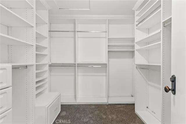 a view of walk in closet with empty racks