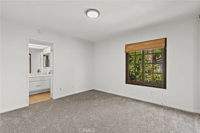 an empty room with a window and a bathroom