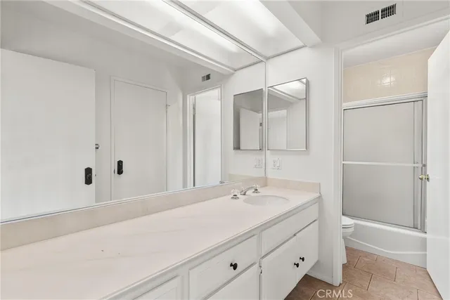 a bathroom with a double vanity sink a mirror and a shower