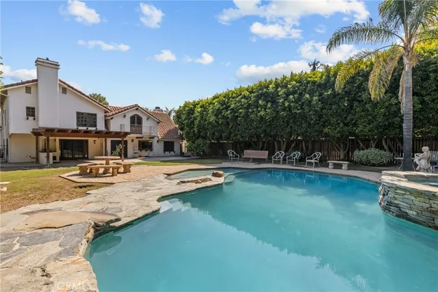a view of a house with swimming pool and sitting area