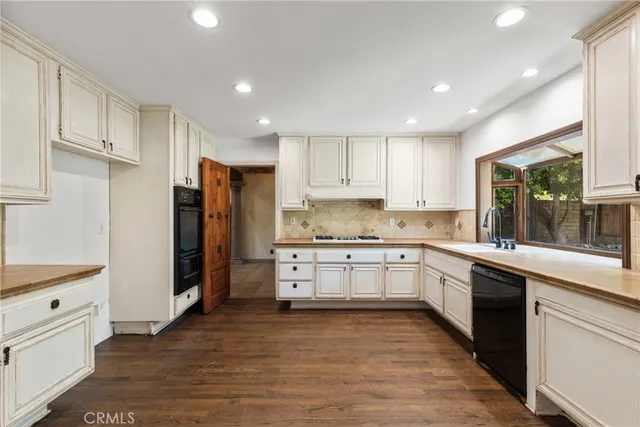 a kitchen with granite countertop white cabinets and refrigerator