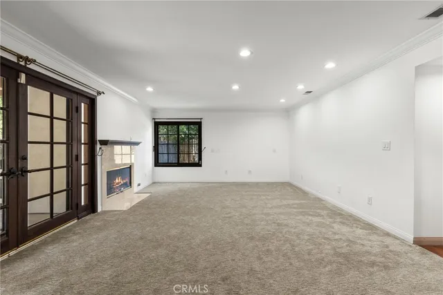 a view of an empty room with a fireplace and windows