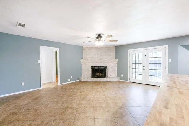 a view of an empty room with a fireplace and a window