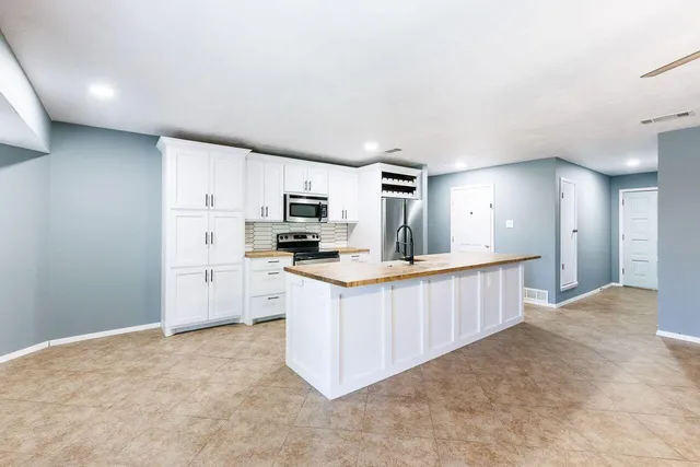 a bathroom with a granite countertop sink a toilet and shower