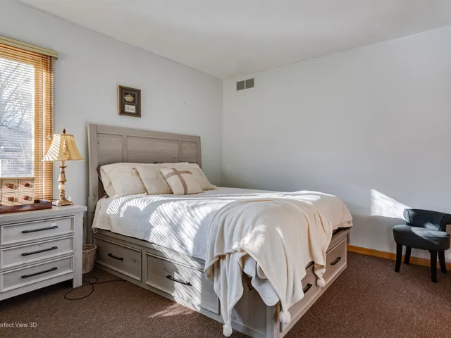 a bedroom with a bed and a dresser in it