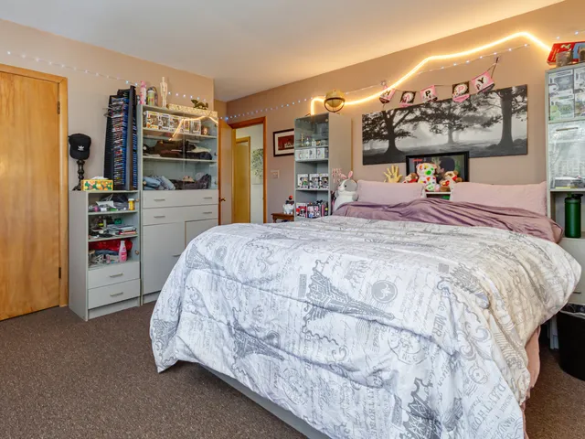 a bed sitting in a bedroom and tv on table