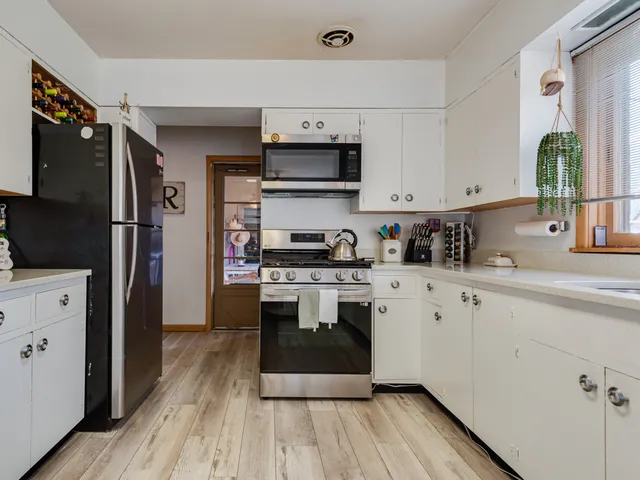 a kitchen with stainless steel appliances a stove a sink a refrigerator and cabinets