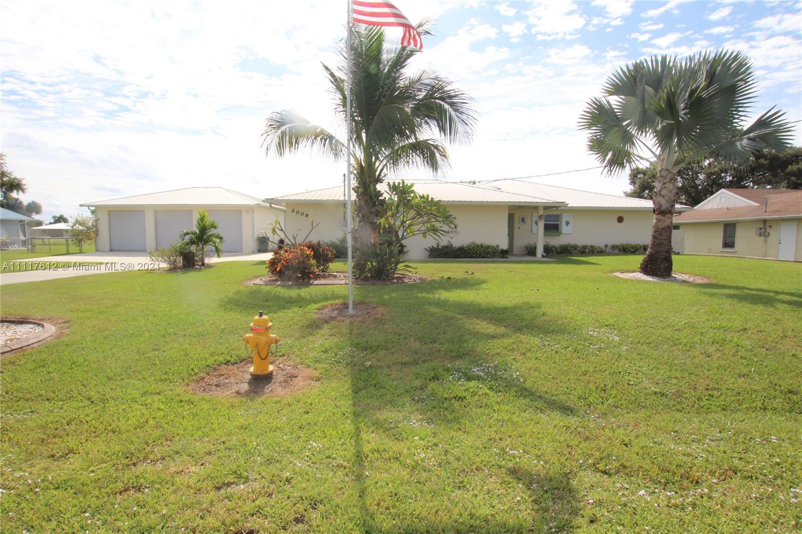 2009 Hunter Road Okeechobee, FL 34974 - Photo 1 of 43 a view of a house with a big yard and palm trees
