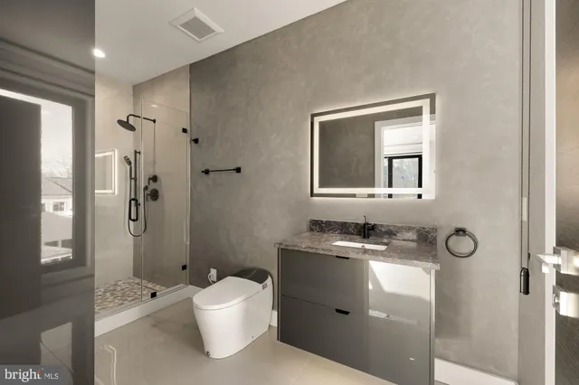 a bathroom with a toilet sink a mirror and shower