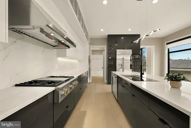 a kitchen with stainless steel appliances a sink a stove and cabinets