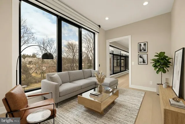a living room with furniture large window and wooden floor