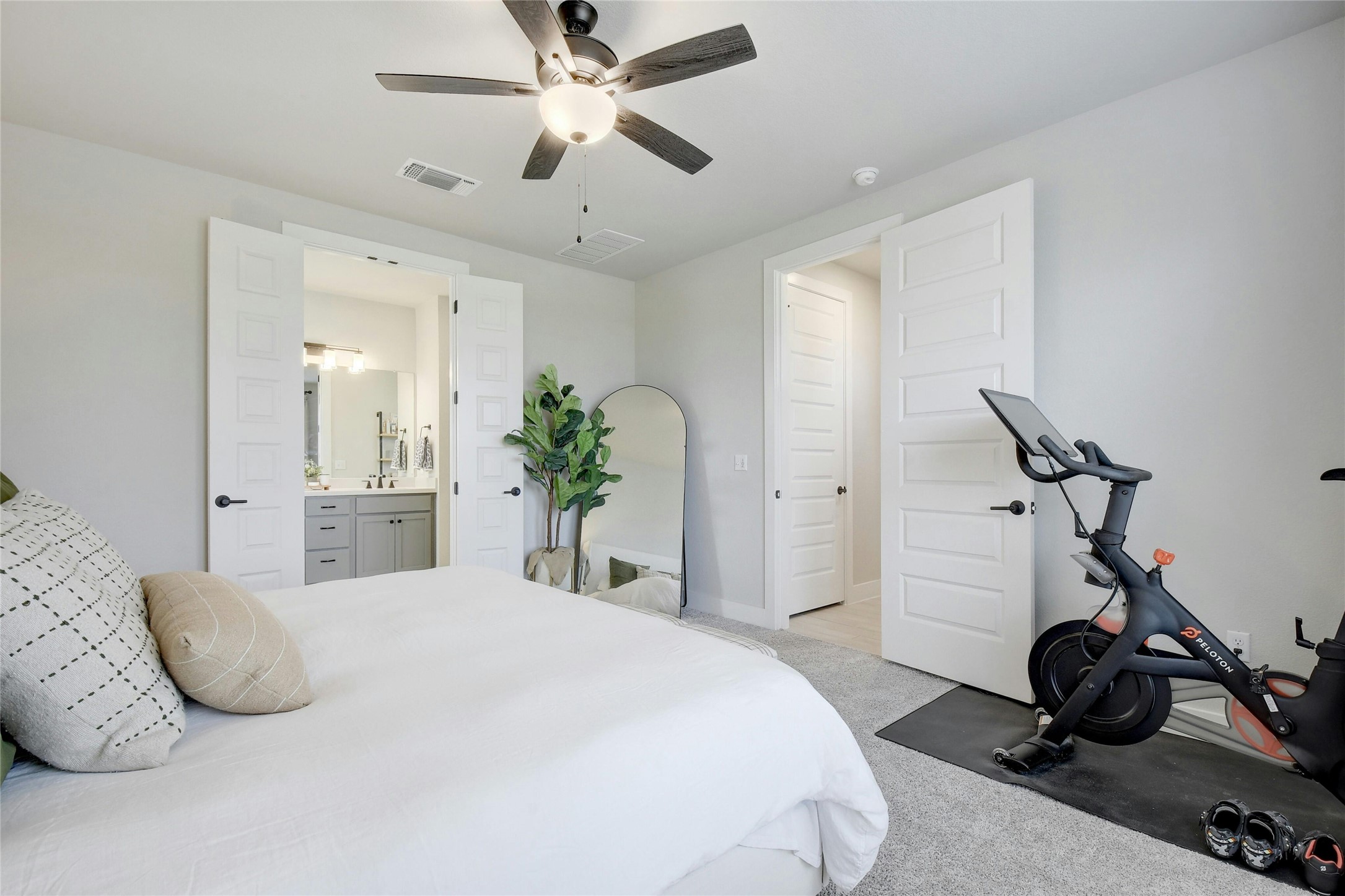 8302 Corrigan Pass Austin, TX 78744 - Photo 16 of 30 Bedroom featuring light colored carpet, ceiling fan, and ensuite bathroom
