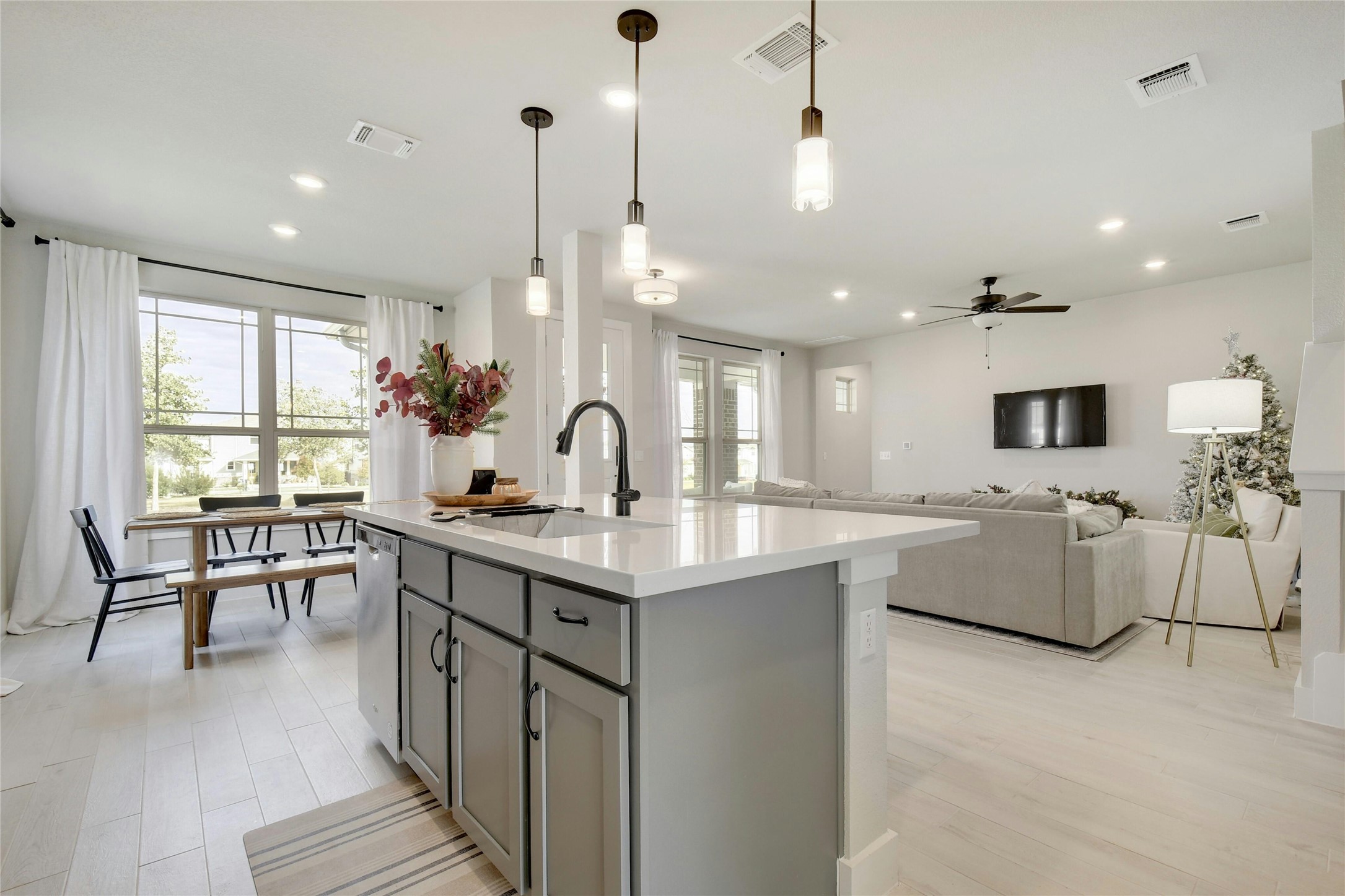 8302 Corrigan Pass Austin, TX 78744 - Photo 30 of 30 Kitchen featuring decorative light fixtures, light wood-style floors, open floor plan, ceiling fan, and an island with sink