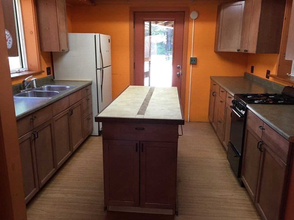 253 Long Plain Road Leverett, MA 01054 - Photo 38 of 42 a kitchen with kitchen island granite countertop wooden cabinets a sink a stove and a refrigerator