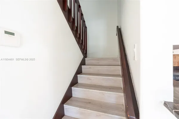 a view of staircase with white walls and a window