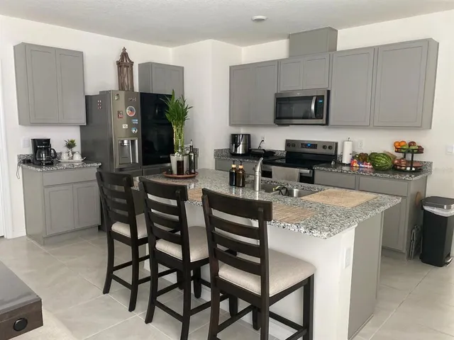 a kitchen with a stove a sink and chairs