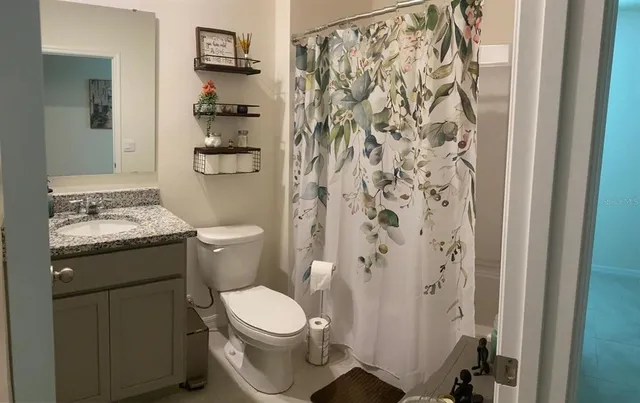 a bathroom with a toilet and a shower curtain